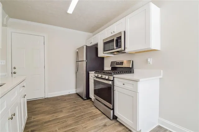 a kitchen with stainless steel appliances granite countertop a stove a microwave and a refrigerator