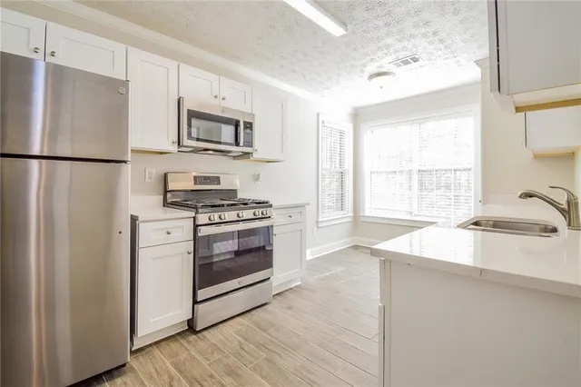 a kitchen with stainless steel appliances a refrigerator sink and stove