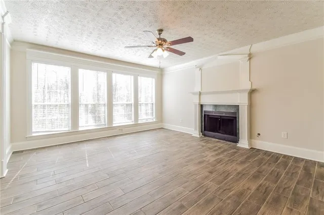 wooden floor fireplace and windows in an empty room