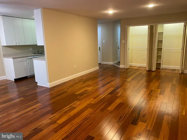 a view of empty room with wooden floor