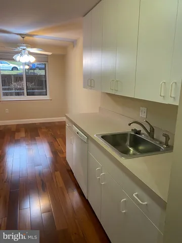 a kitchen with a sink and wooden floor