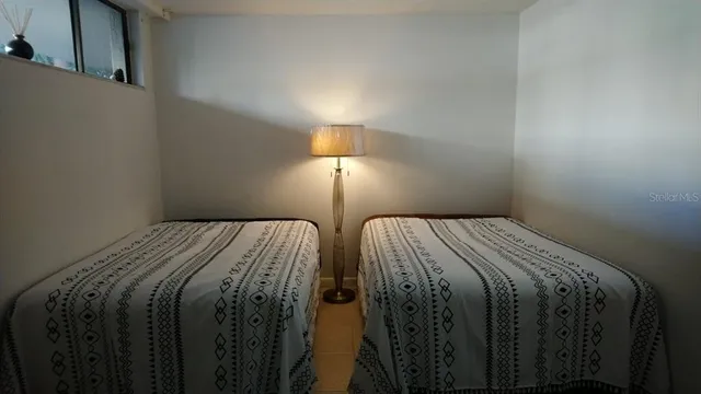 a bed sitting in a bedroom next to a lamp