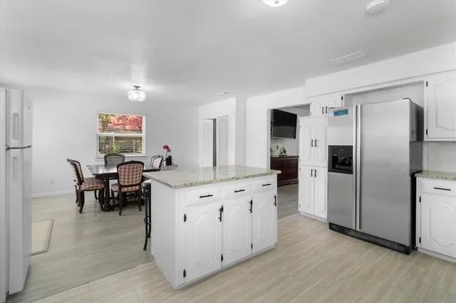 a kitchen with kitchen island a counter top space and stainless steel appliances