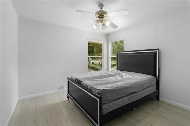 a bed sitting in a spacious bedroom next to a window