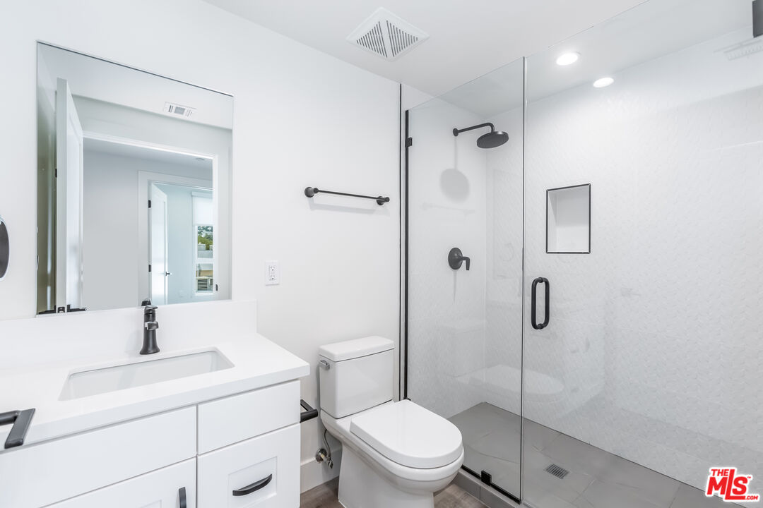 857 North Hayworth Avenue, Unit 403 Los Angeles, CA 90046 - Photo 11 of 52 a bathroom with a toilet sink vanity and shower