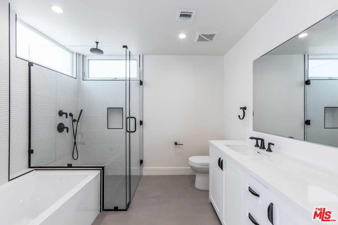 857 North Hayworth Avenue, Unit 403 Los Angeles, CA 90046 - Photo 12 of 52 a bathroom with a bathtub shower sink mirror and toilet