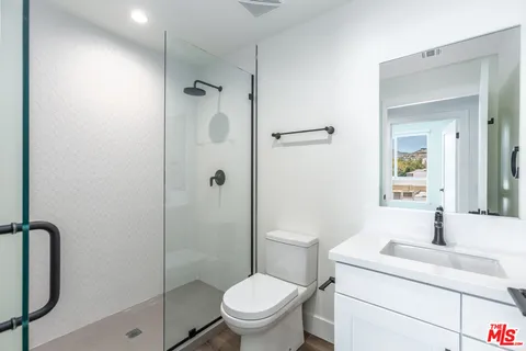 a bathroom with a granite countertop sink toilet and shower