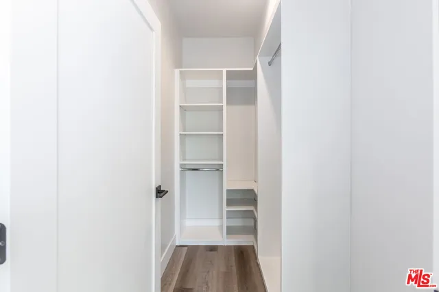 a view of a walk in closet with wooden floor