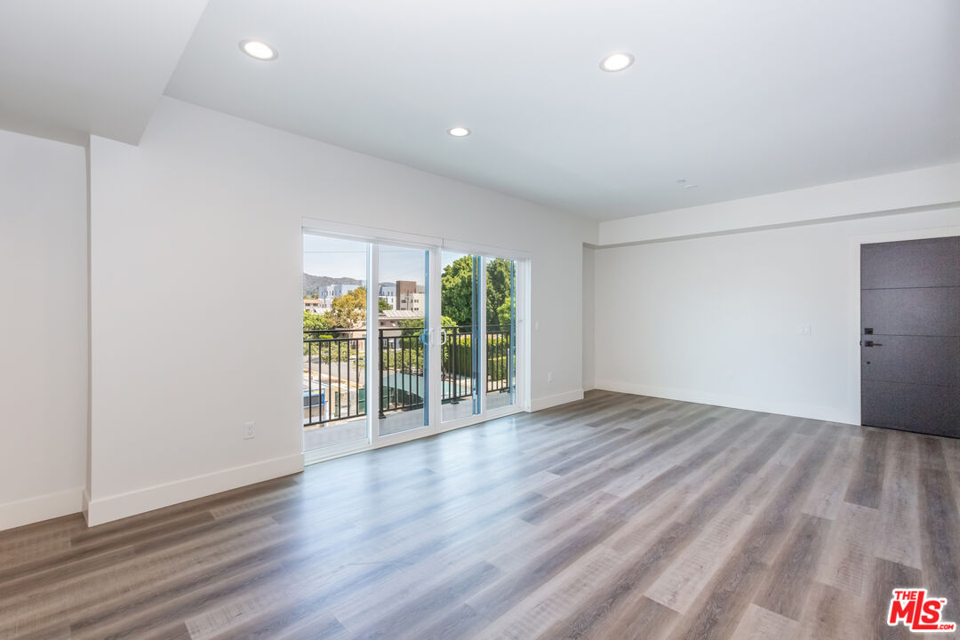 857 North Hayworth Avenue, Unit 403 Los Angeles, CA 90046 - Photo 33 of 52 a view of an empty room with wooden floor and a window