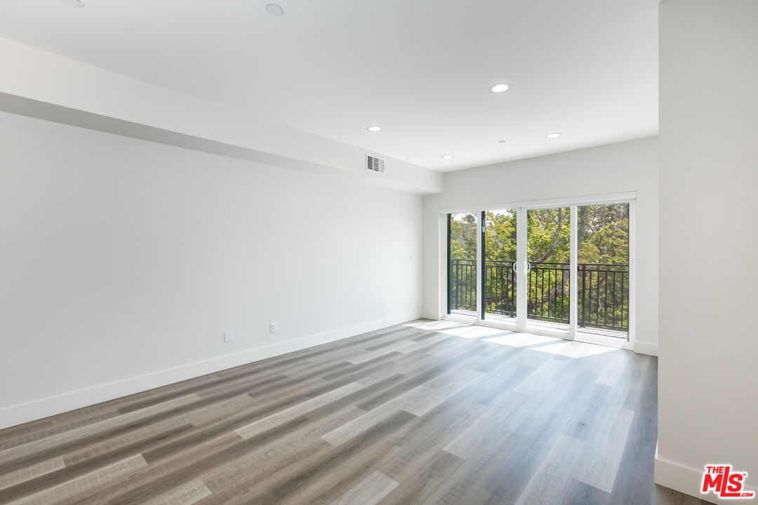 857 North Hayworth Avenue, Unit 403 Los Angeles, CA 90046 - Photo 6 of 52 a view of an empty room with wooden floor and a window