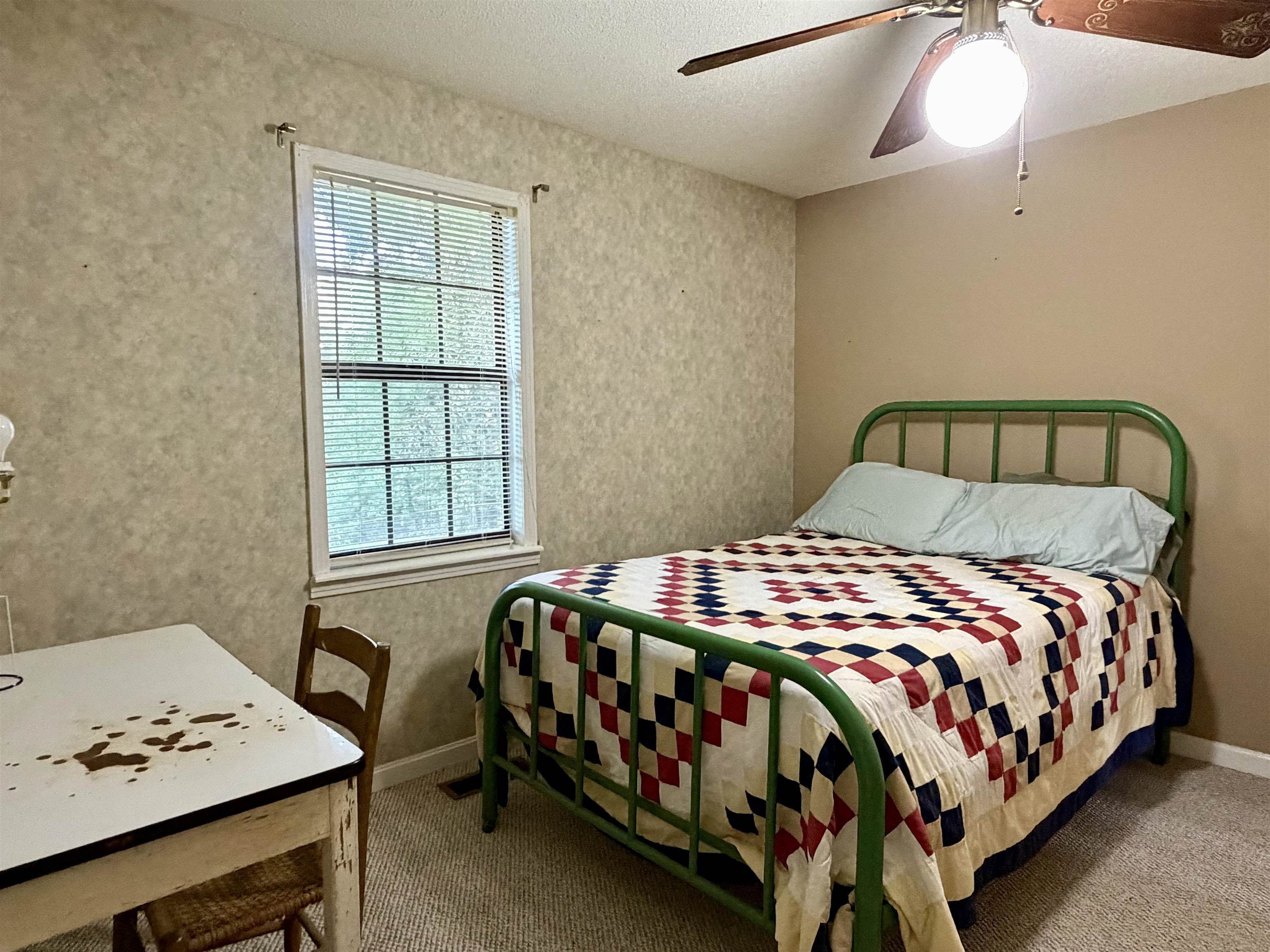 373 Clarence Barham Road Bethel Springs, TN 38315 - Photo 16 of 28 Bedroom featuring a window with blinds, textured wallpaper, neutral painted walls, carpeted flooring, and a ceiling fan with light fixture