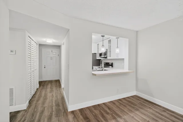 a kitchen with stainless steel appliances white cabinets white stove a microwave and a refrigerator