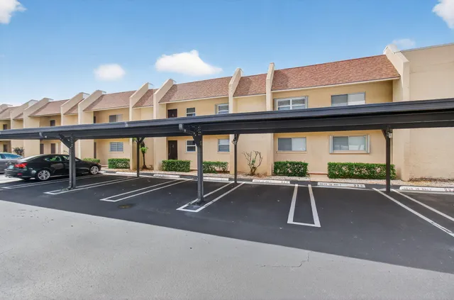 a view of a patio with a table and chairs under an umbrellas