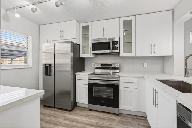 a kitchen with stainless steel appliances a refrigerator and a window