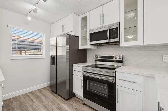 a kitchen with stainless steel appliances a stove microwave and sink