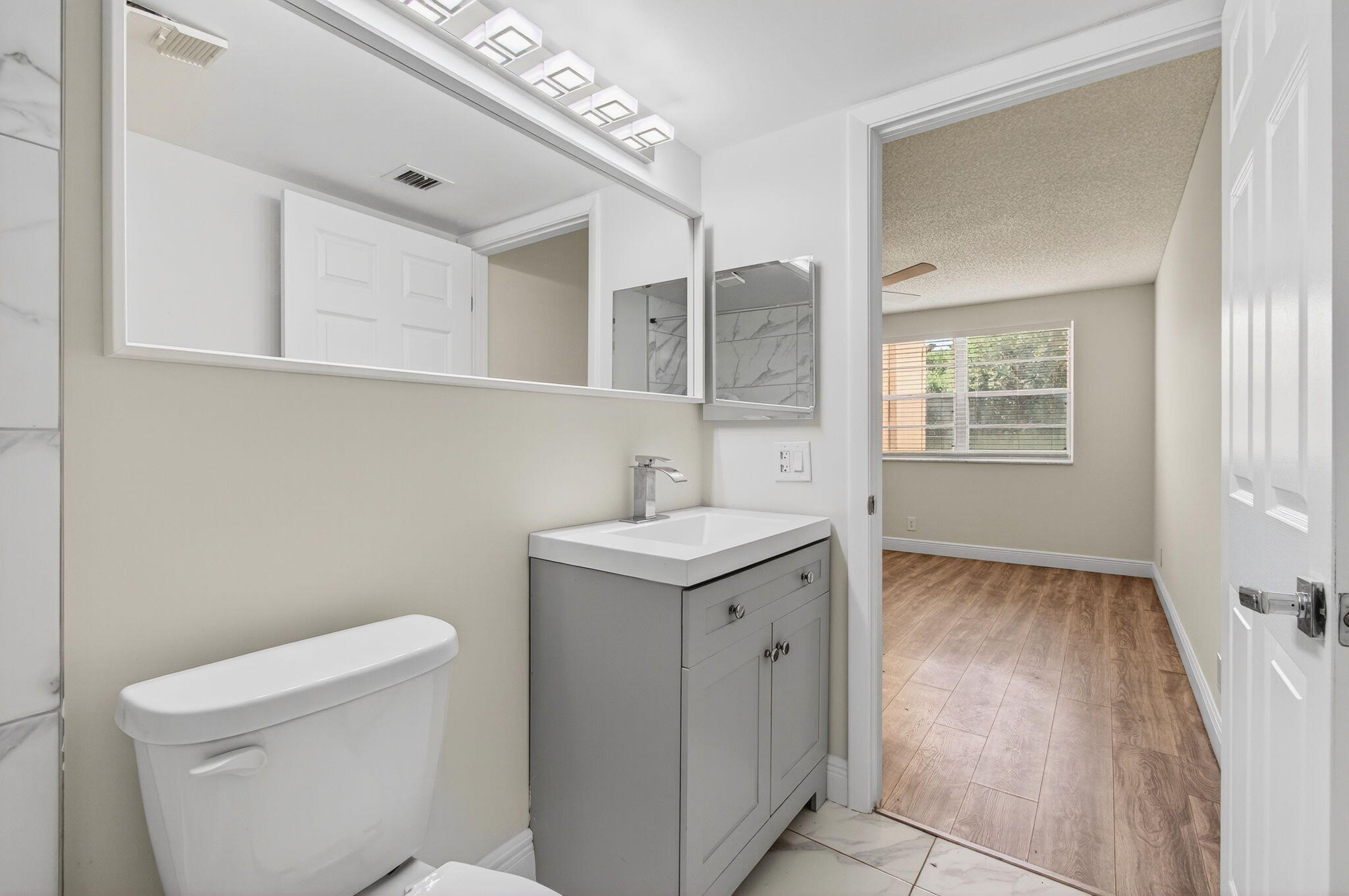 2975 Southwest 22nd Avenue, Unit 1070 Delray Beach, FL 33445 - Photo 35 of 60 a bathroom with a sink a toilet and window