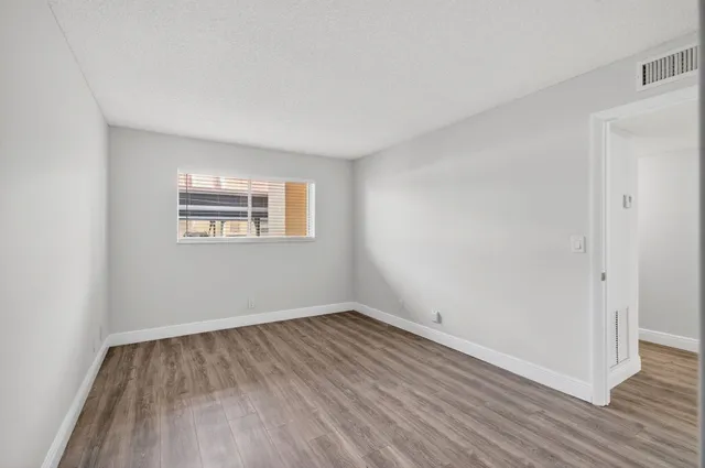 a view of an empty room and wooden floor
