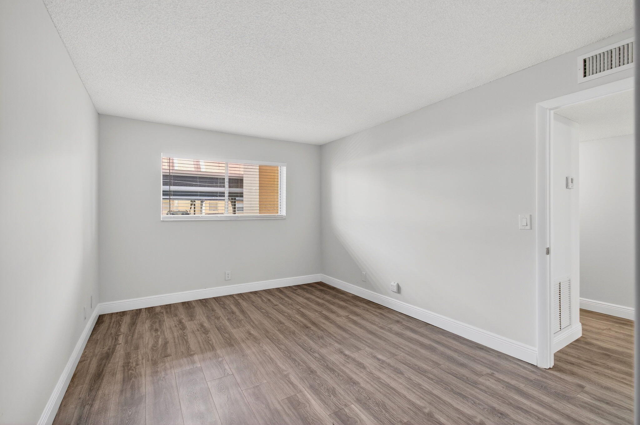 2975 Southwest 22nd Avenue, Unit 1070 Delray Beach, FL 33445 - Photo 37 of 60 an empty room with wooden floor and windows