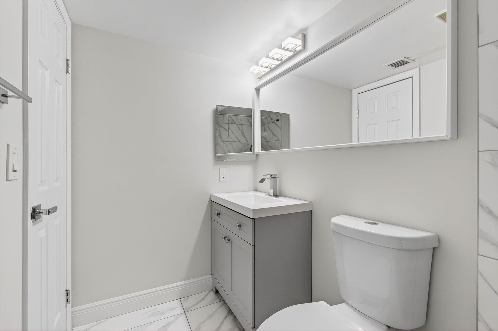 2975 Southwest 22nd Avenue, Unit 1070 Delray Beach, FL 33445 - Photo 43 of 60 a bathroom with a toilet sink and mirror