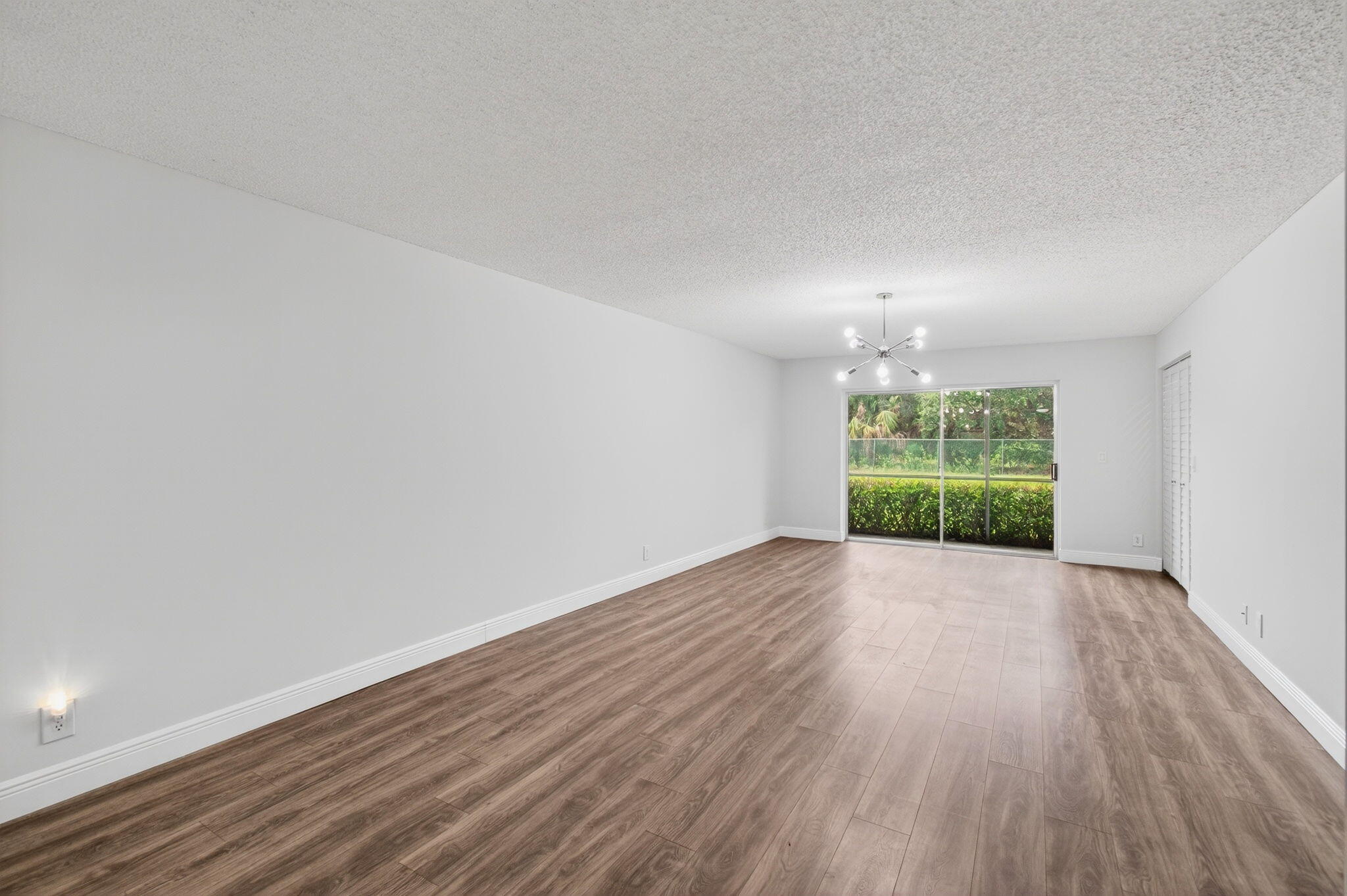 2975 Southwest 22nd Avenue, Unit 1070 Delray Beach, FL 33445 - Photo 9 of 60 a view of an empty room with wooden floor and a window
