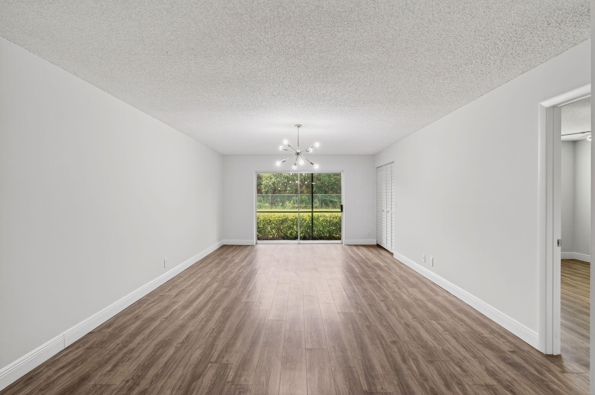 2975 Southwest 22nd Avenue, Unit 1070 Delray Beach, FL 33445 - Photo 10 of 60 an empty room with wooden floor and windows