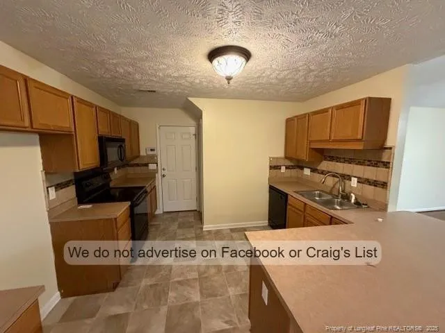 a kitchen with stainless steel appliances granite countertop a refrigerator oven a stove top oven and a sink with wooden floor