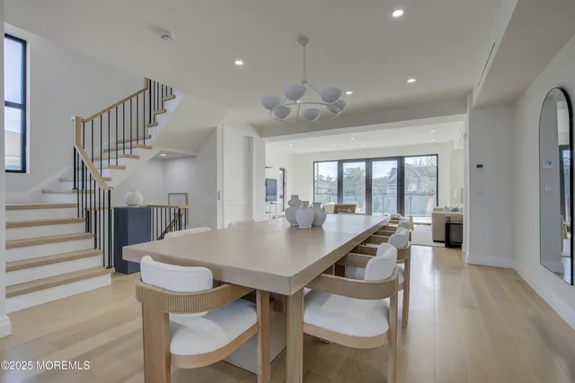 a view of a dining room with furniture a chandelier and wooden floor