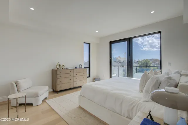 a bedroom with a bed and large windows