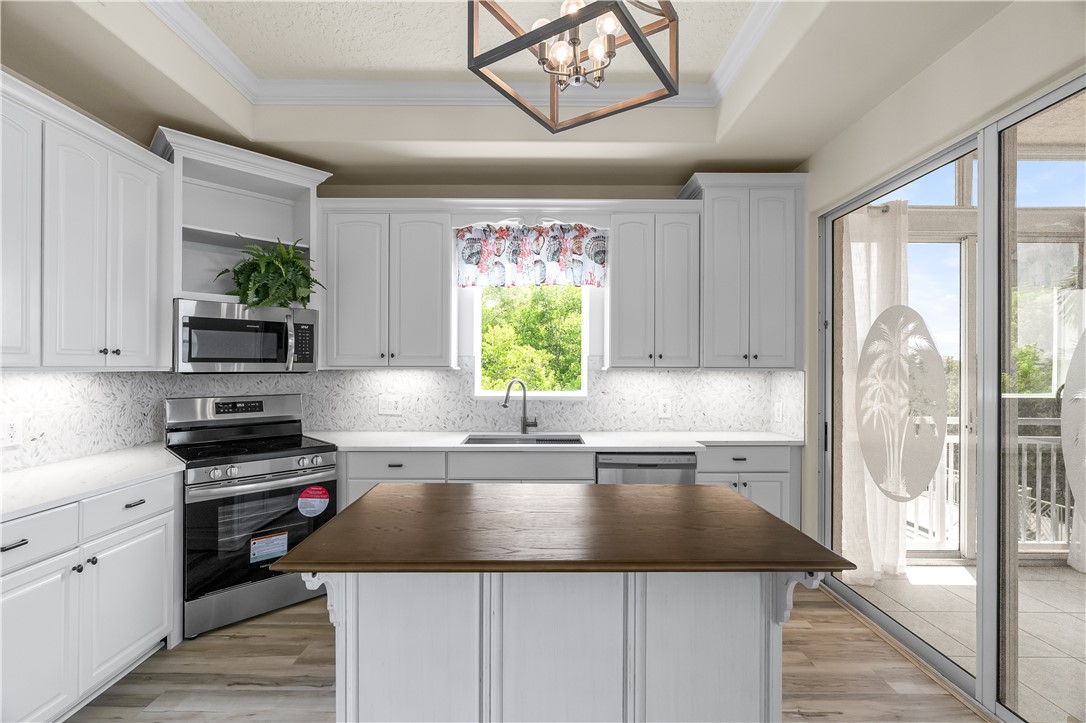 1701 Gulfstream Avenue, Unit 729 Fort Pierce, FL 34949 - Photo 14 of 36 a kitchen with a sink a counter top space cabinets and stainless steel appliances