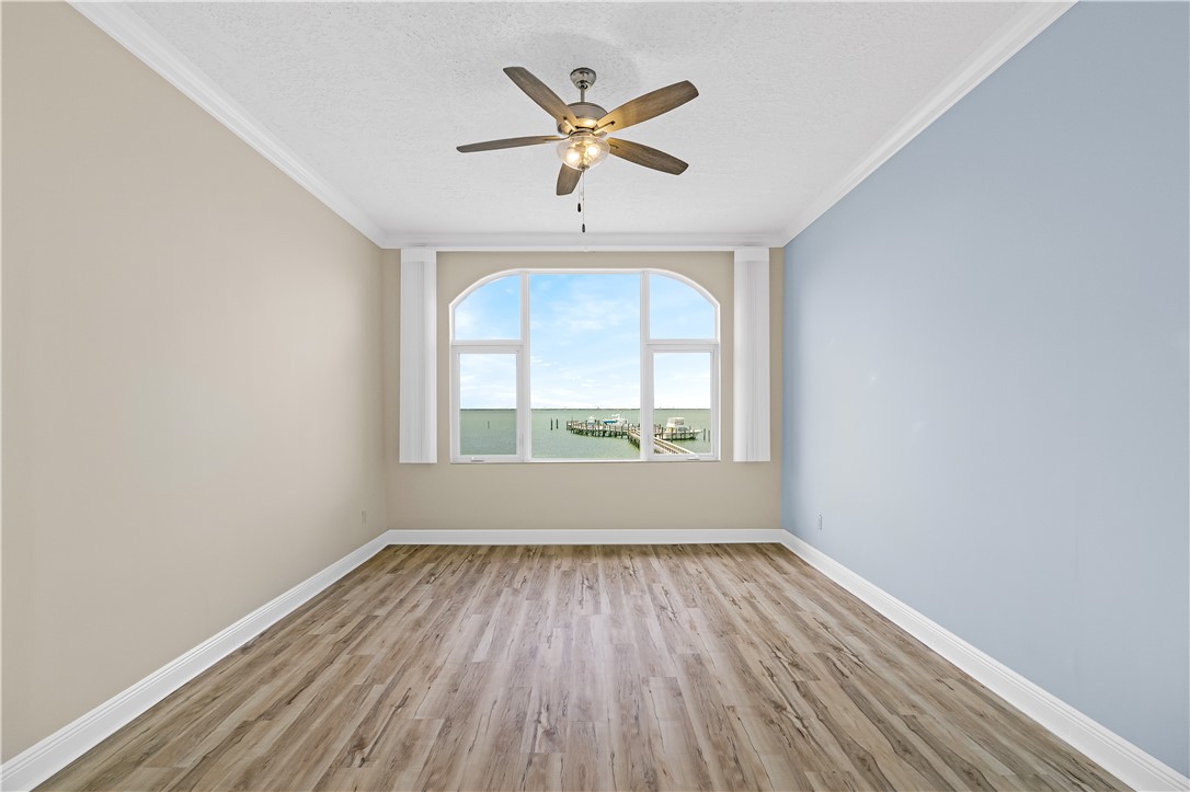 1701 Gulfstream Avenue, Unit 729 Fort Pierce, FL 34949 - Photo 16 of 36 an empty room with wooden floor a ceiling fan and windows