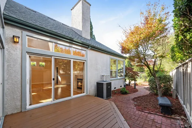 a view of an empty room with wooden floor fireplace and a window