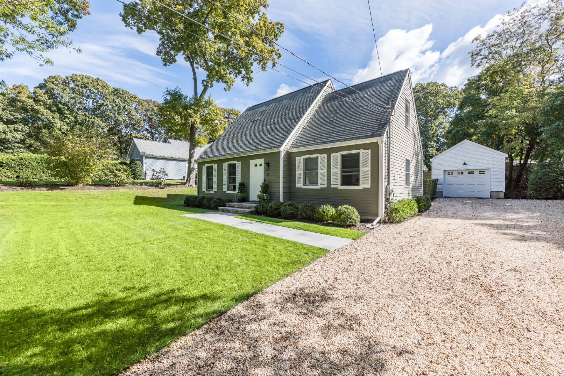 a front view of a house with a yard and potted plants