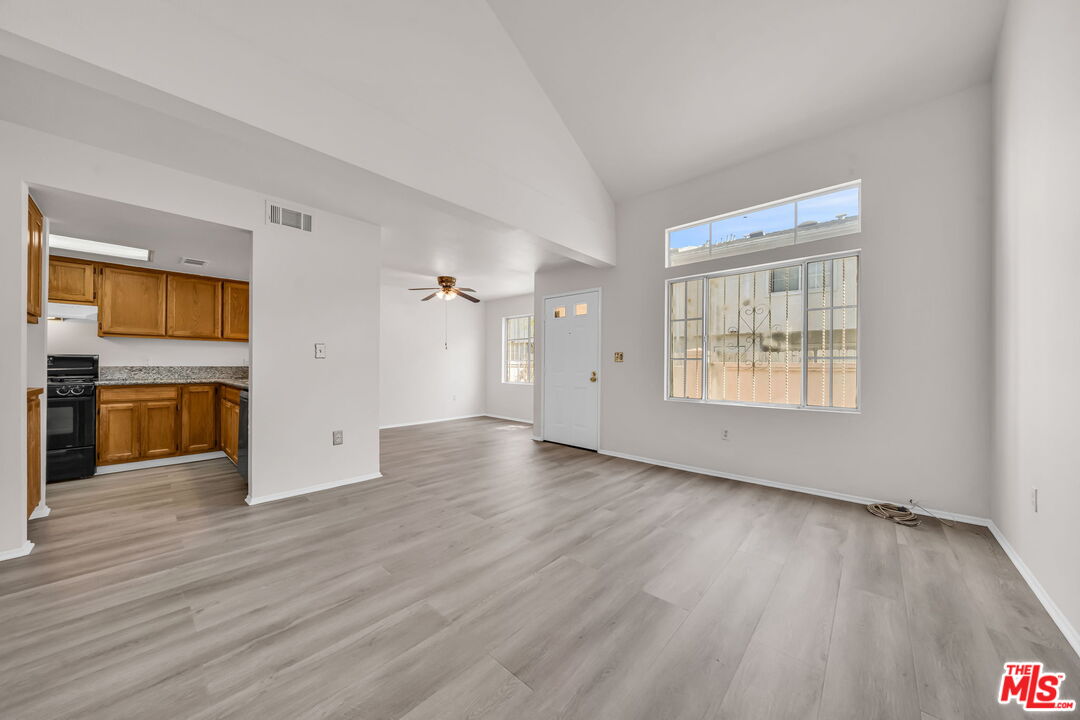820 West Compton Boulevard, Unit 17 Compton, CA 90220 - Photo 7 of 50 an empty room with wooden floor kitchen view and a window