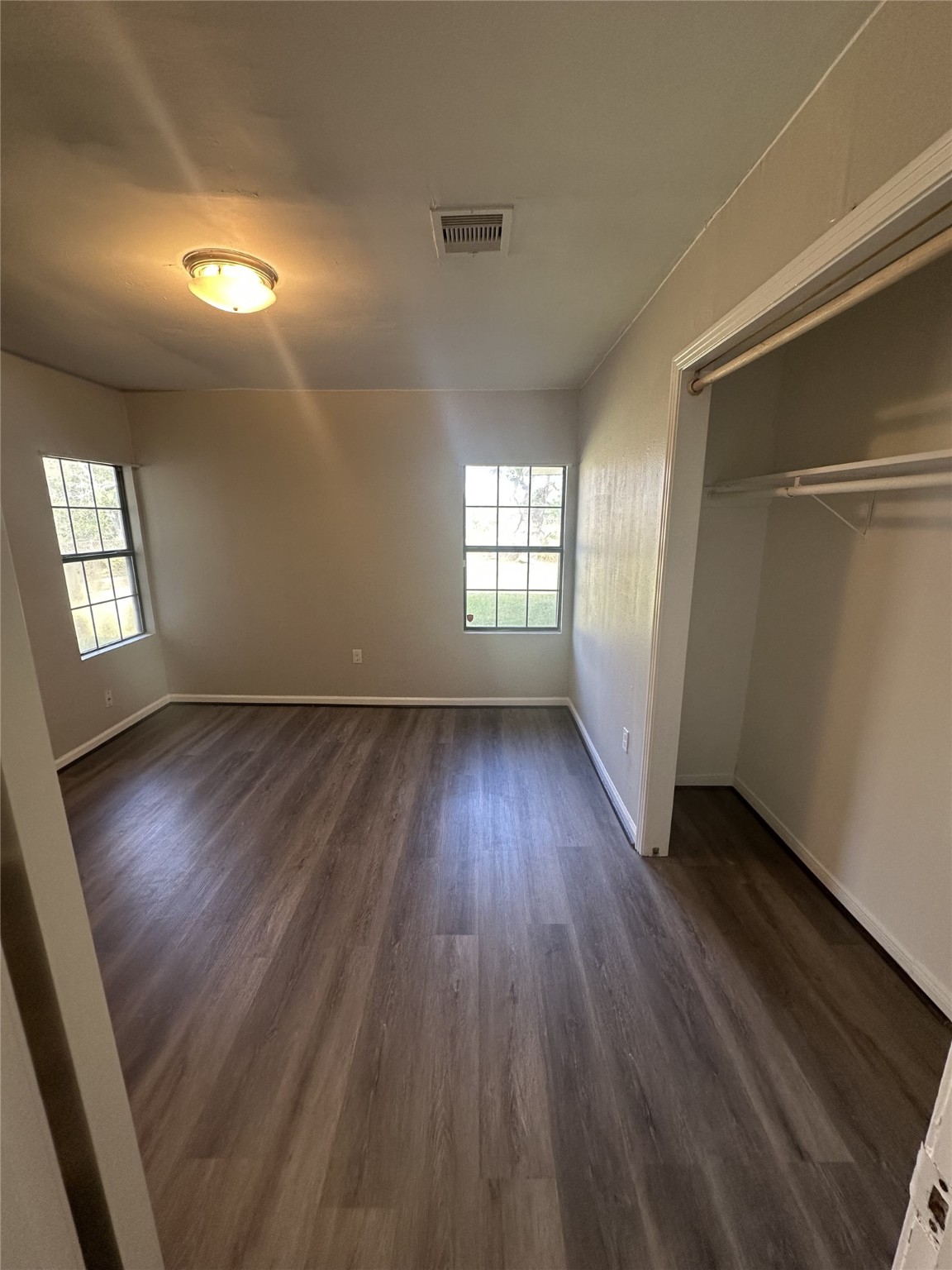 5847 Belcrest Street Houston, TX 77033 - Photo 3 of 7 an empty room with wooden floor and windows