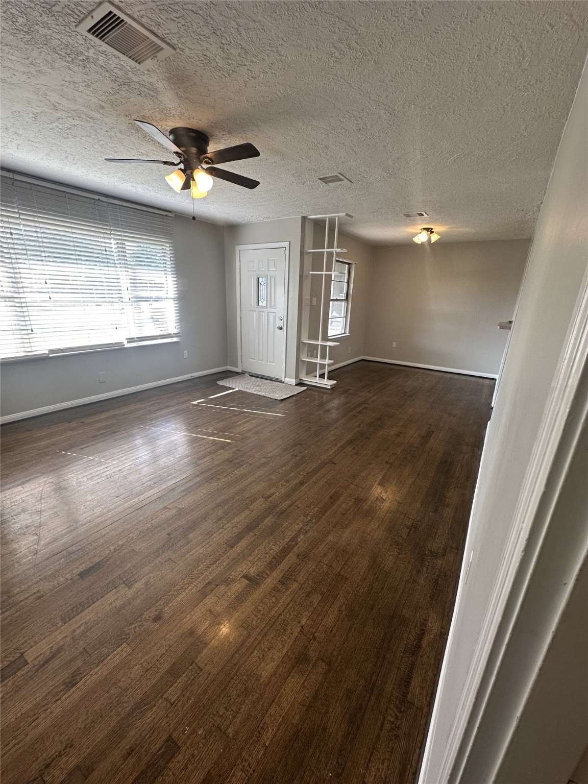5847 Belcrest Street Houston, TX 77033 - Photo 7 of 7 a view of an empty room with wooden floor and a window