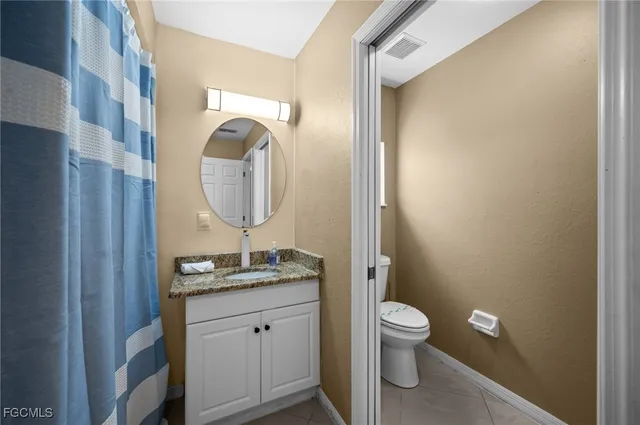 a bathroom with a toilet a sink and a mirror