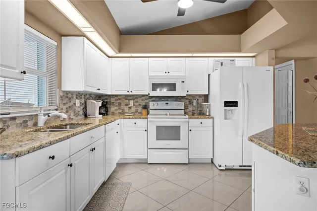 a kitchen with white cabinets and white appliances