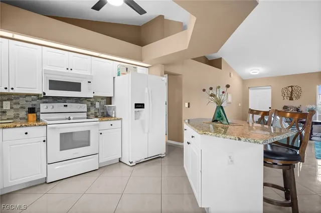a kitchen with white cabinets and white appliances