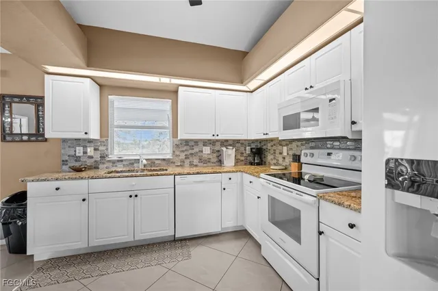 a kitchen with cabinets appliances a sink and a window