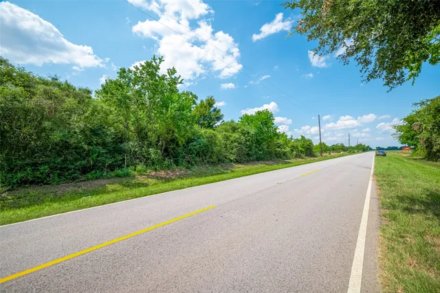 a view of green field with trees in the background