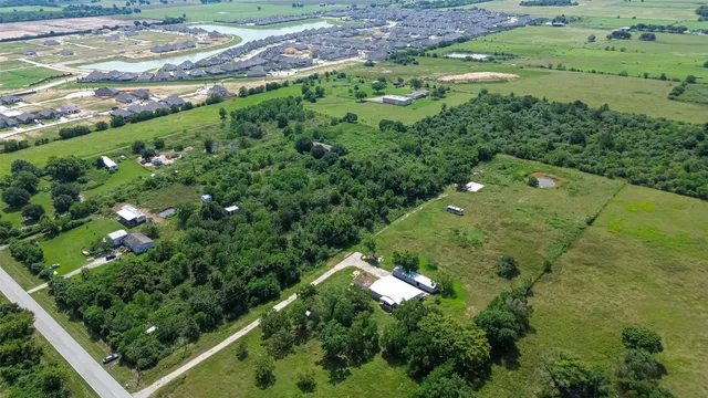 an aerial view of a residential houses with outdoor space and street view