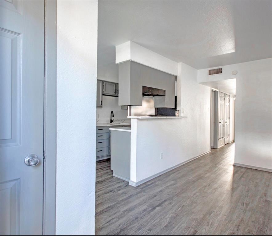 916 Isbell Road, Unit D Fort Worth, TX 76114 - Photo 2 of 13 a kitchen with a refrigerator cabinets and wooden floor