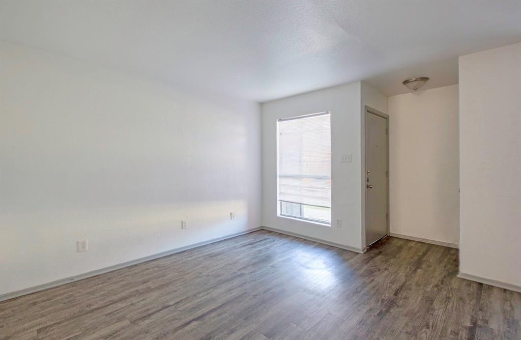 916 Isbell Road, Unit D Fort Worth, TX 76114 - Photo 6 of 13 an empty room with wooden floor and window