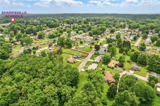 an aerial view of residential houses with outdoor space and trees