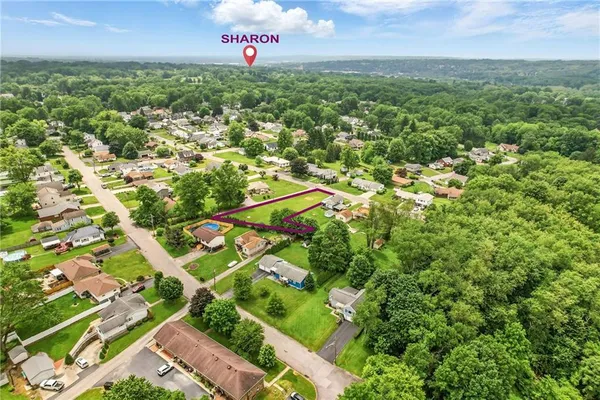 an aerial view of residential houses with outdoor space and trees