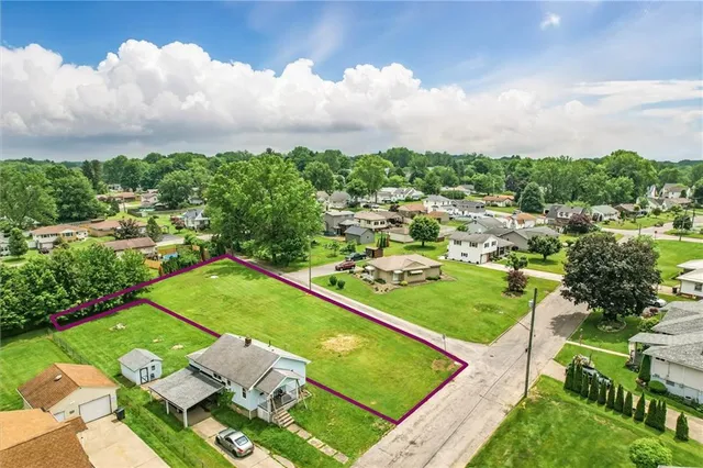 a view of a tennis ground with large trees