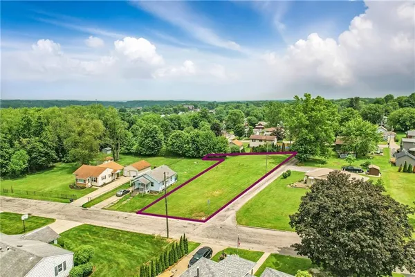 an aerial view of residential houses with outdoor space and street view