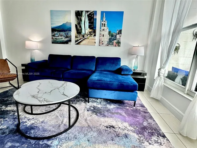 a living room with furniture a rug and white walls