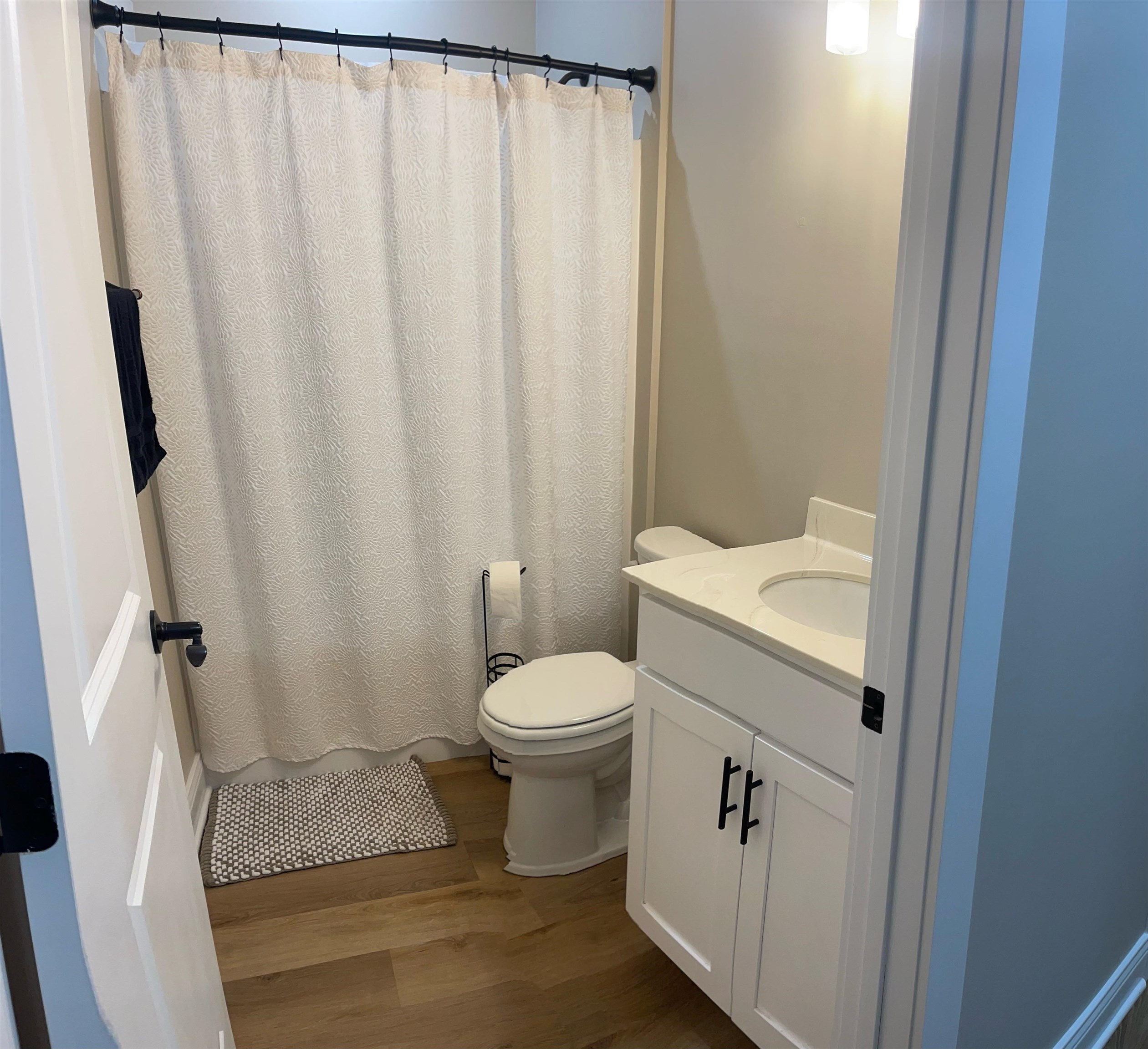 210 Church Street Ripley, TN 38063 - Photo 16 of 21 Bathroom with vanity, dark wood-type flooring, and a shower with curtain