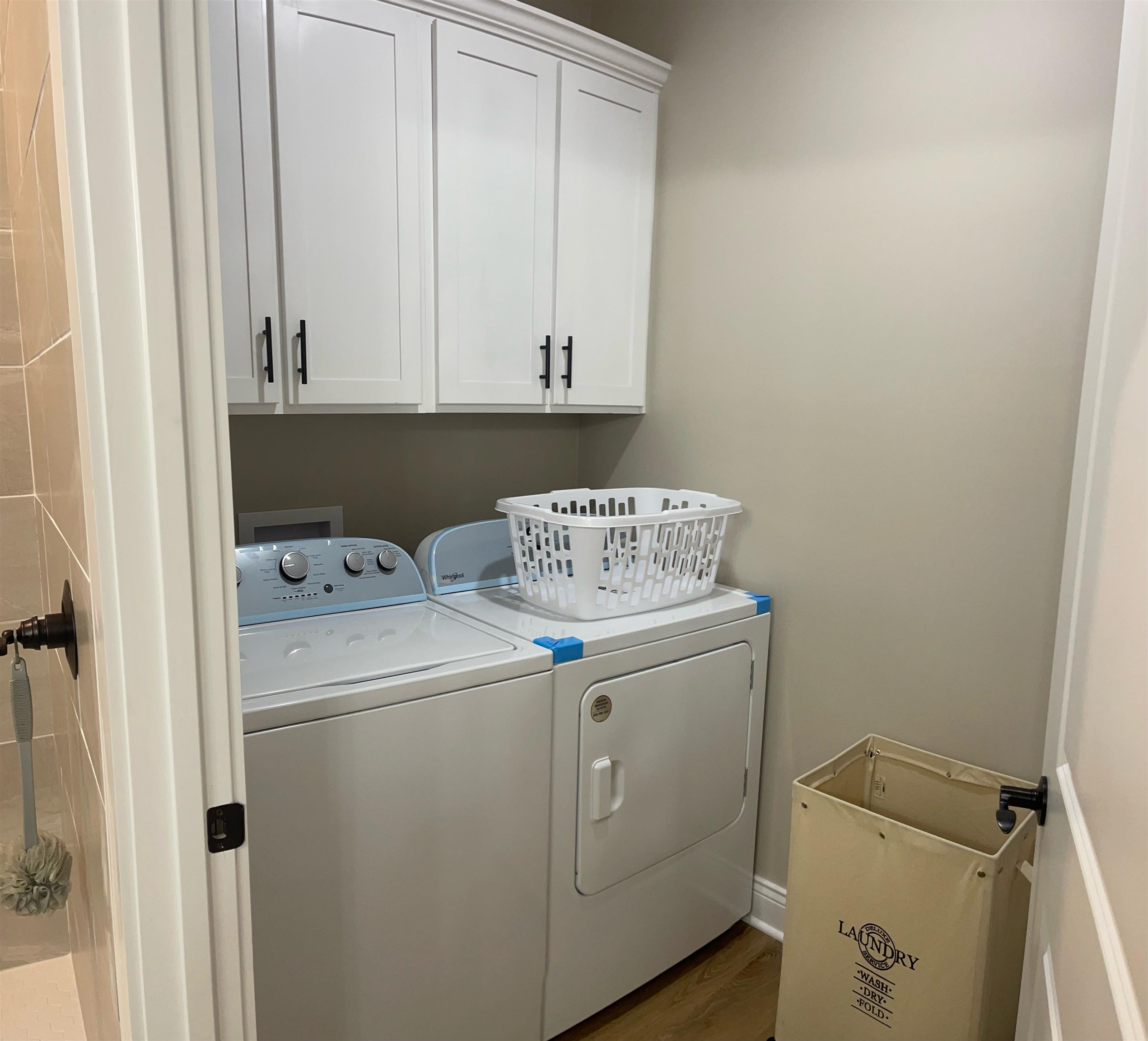 210 Church Street Ripley, TN 38063 - Photo 18 of 21 Laundry room with wood finished floors, cabinet space, and washer and dryer